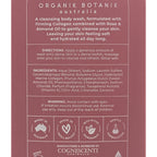 The back of a COSNESCENTI Organik Botanik Australia cleansing body wash bottle, showing product details, directions, ingredients, and feature icons in white text on a dusty rose background.