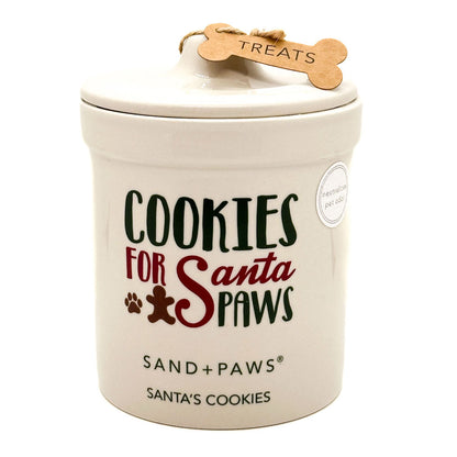 Ceramic candle treat jar with 'Cookies for Santa Paws' text and Sand + Paws branding.