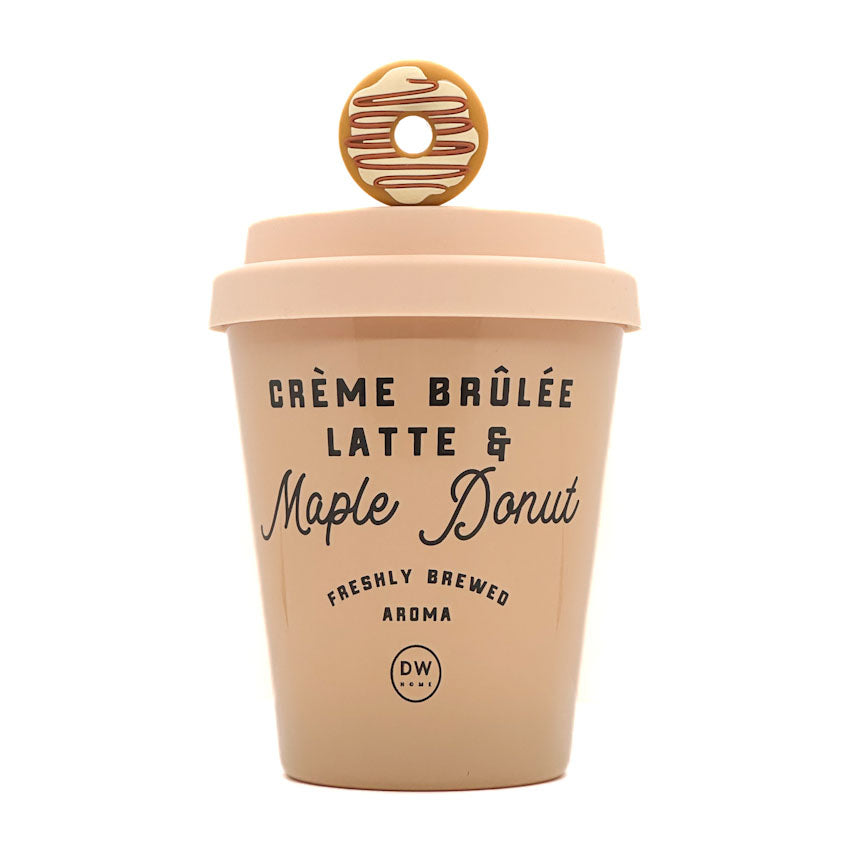 A light peach-colored ceramic coffee cup designed like a takeaway latte container, featuring a lid with a donut-shaped handle and printed text reading 'CRÈME BRÚLÉE LATTE & Maple Donut' on a white background.