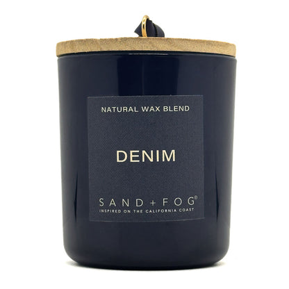 Navy candle with 'Denim' label and 'Sand + Fog' branding on a white background