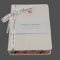Scented journal with peach design and ribbon on a gray background