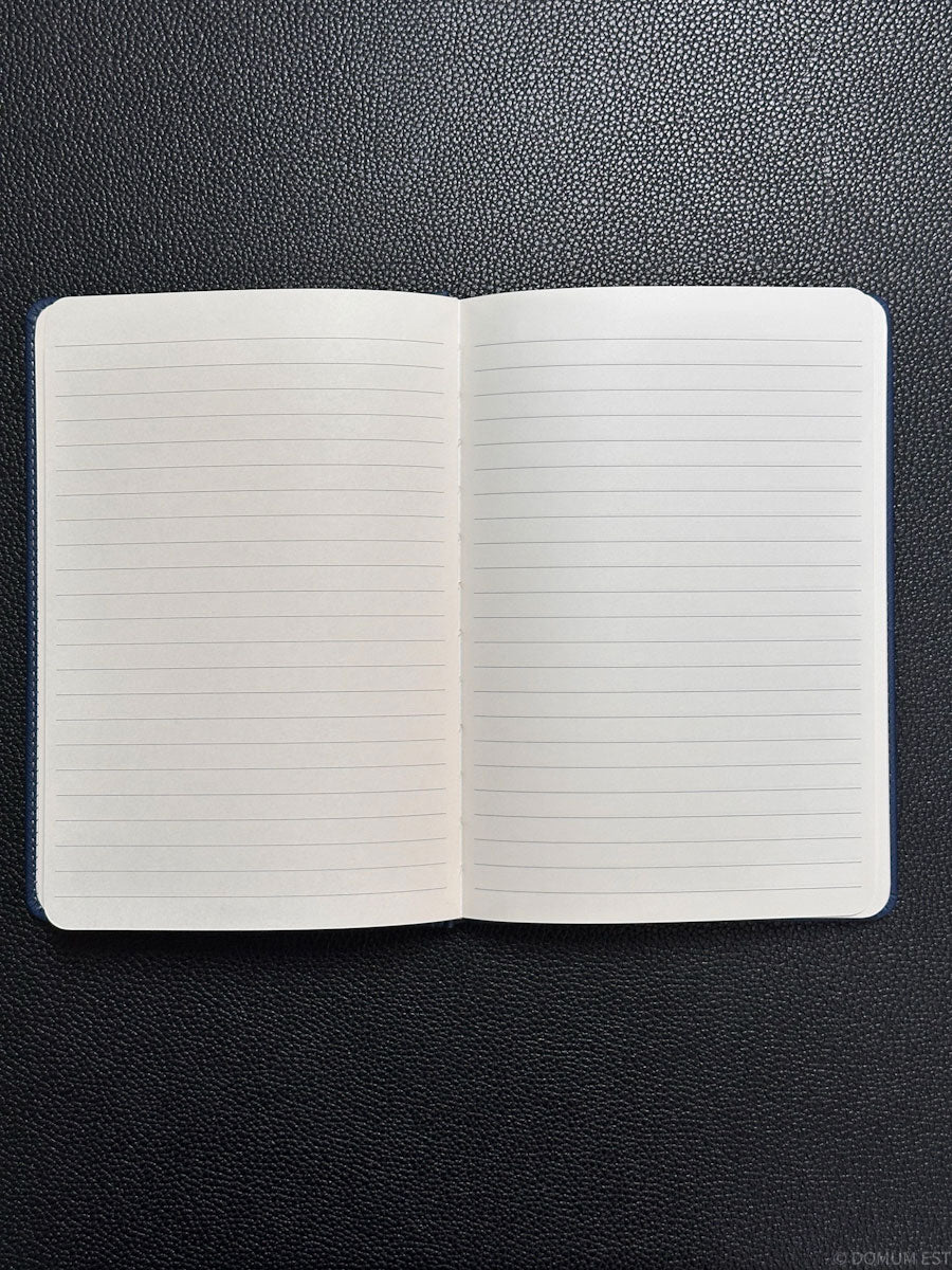 Open notebook with lined pages on a black textured surface