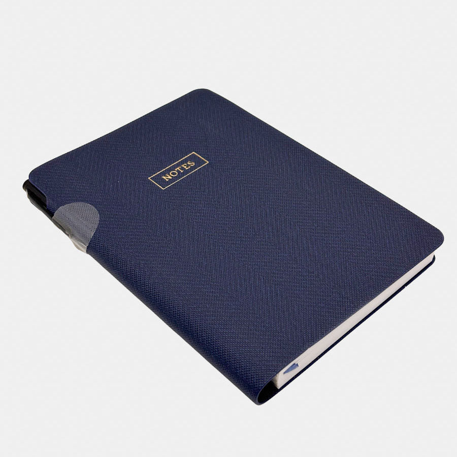 Eccolo navy blue textured notebook with a small gold 'NOTES' label on the cover, shown at an angle on a light grey background.
