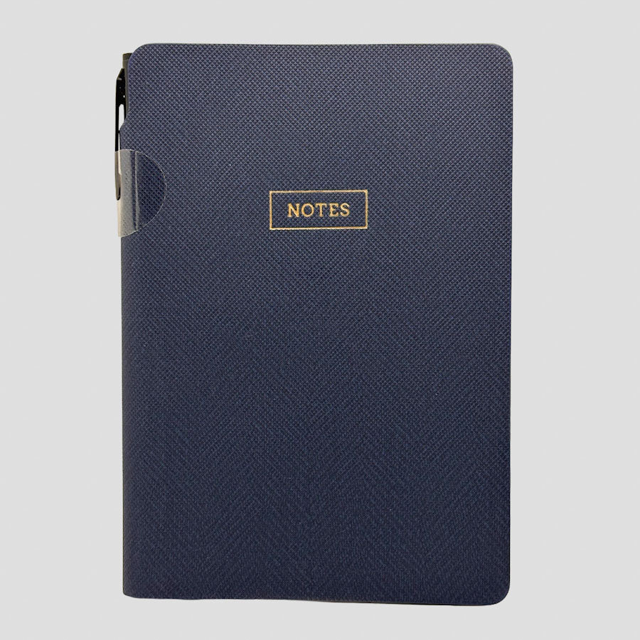 A navy blue textured hardcover notebook with a gold foil 'NOTES' label on the front, shown against a light gray background.