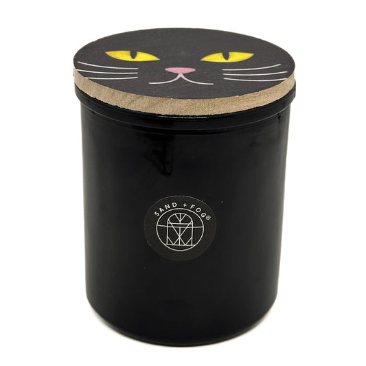 SAND + FOG Falling Leaves black votive candle with a cat face design on the lid on a white background