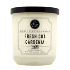 Candle with a label indicating 'Fresh Cut Gardenia' fragrance on a white background