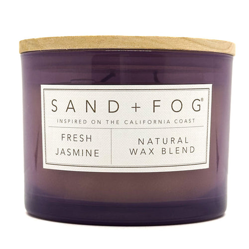 Purple SAND + FOG candle with a wooden lid and 'Sand + Fog' label on a white background
