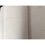 An open planner or notebook showing lined weekly and daily pages for March 2027, photographed against a white background.