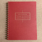 Fringe Studio cherry notebook with a spiral binding on a beige textured background