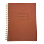 Brown notebook with gold spiral binding on a white background