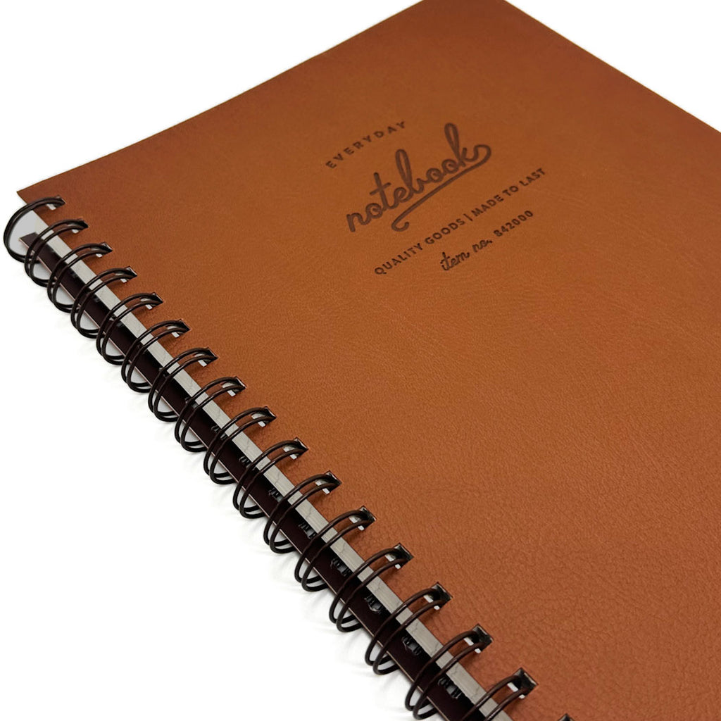 Brown notebook with spiral binding on a white background