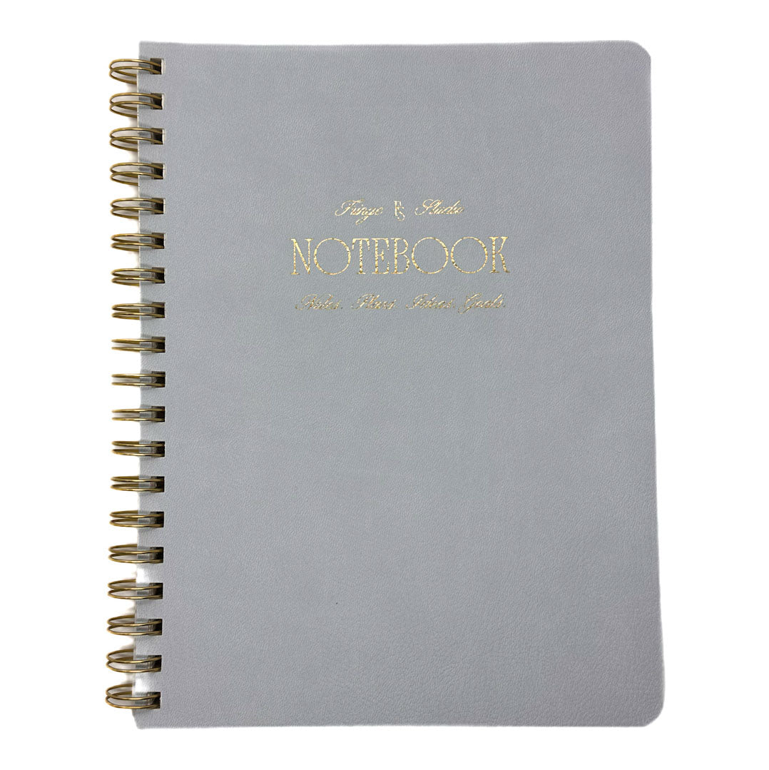 Fringe Studio blue notebook with gold spiral binding and 'Notebook' text on a white background