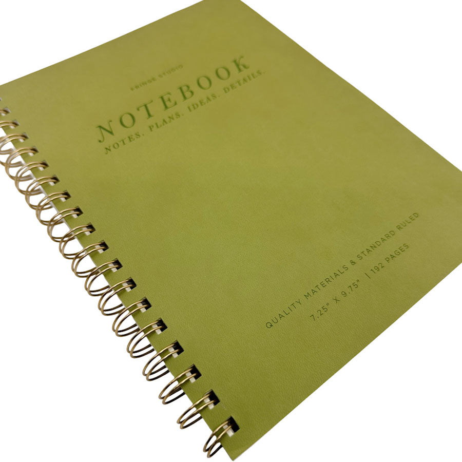 A spiral-bound notebook with a muted olive green cover, featuring gold-toned metal wire binding and embossed text on the front.