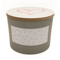 Gardenia cylindrical candle with a heart design on the lid and label, on a white background