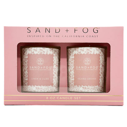 Sand + Fog candle set in pink packaging with two candles visible.