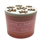Golden Nutmeg Candle with paw print design lid labeled 'Sand + Paws' on a white background