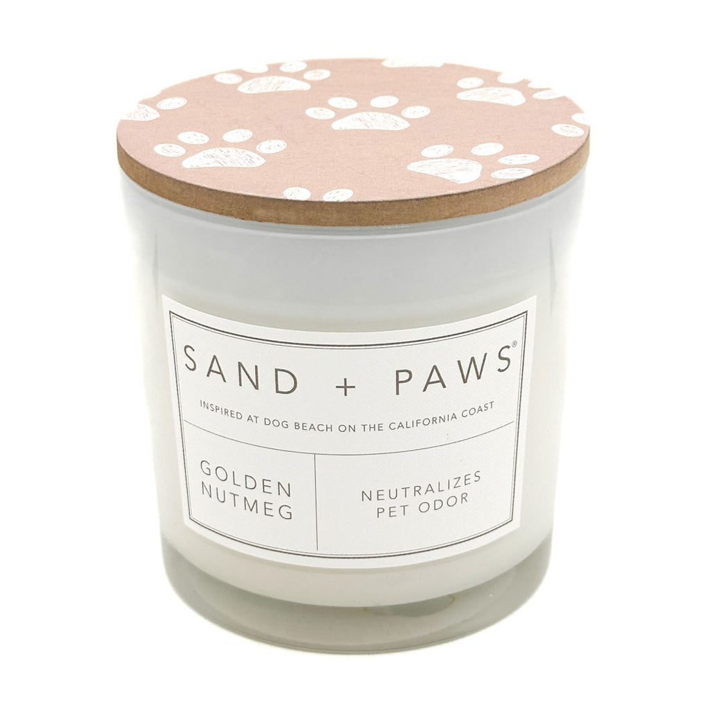 Golden Nutmeg Candle with a paw print lid labeled 'Sand + Paws' on a white background