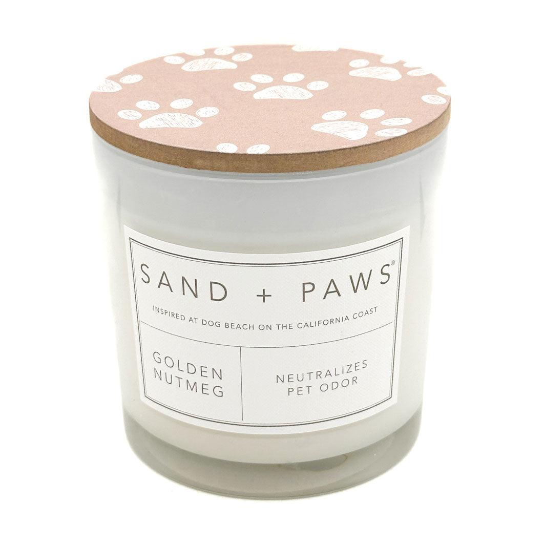 Golden Nutmeg Candle with a paw print lid labeled 'Sand + Paws' on a white background