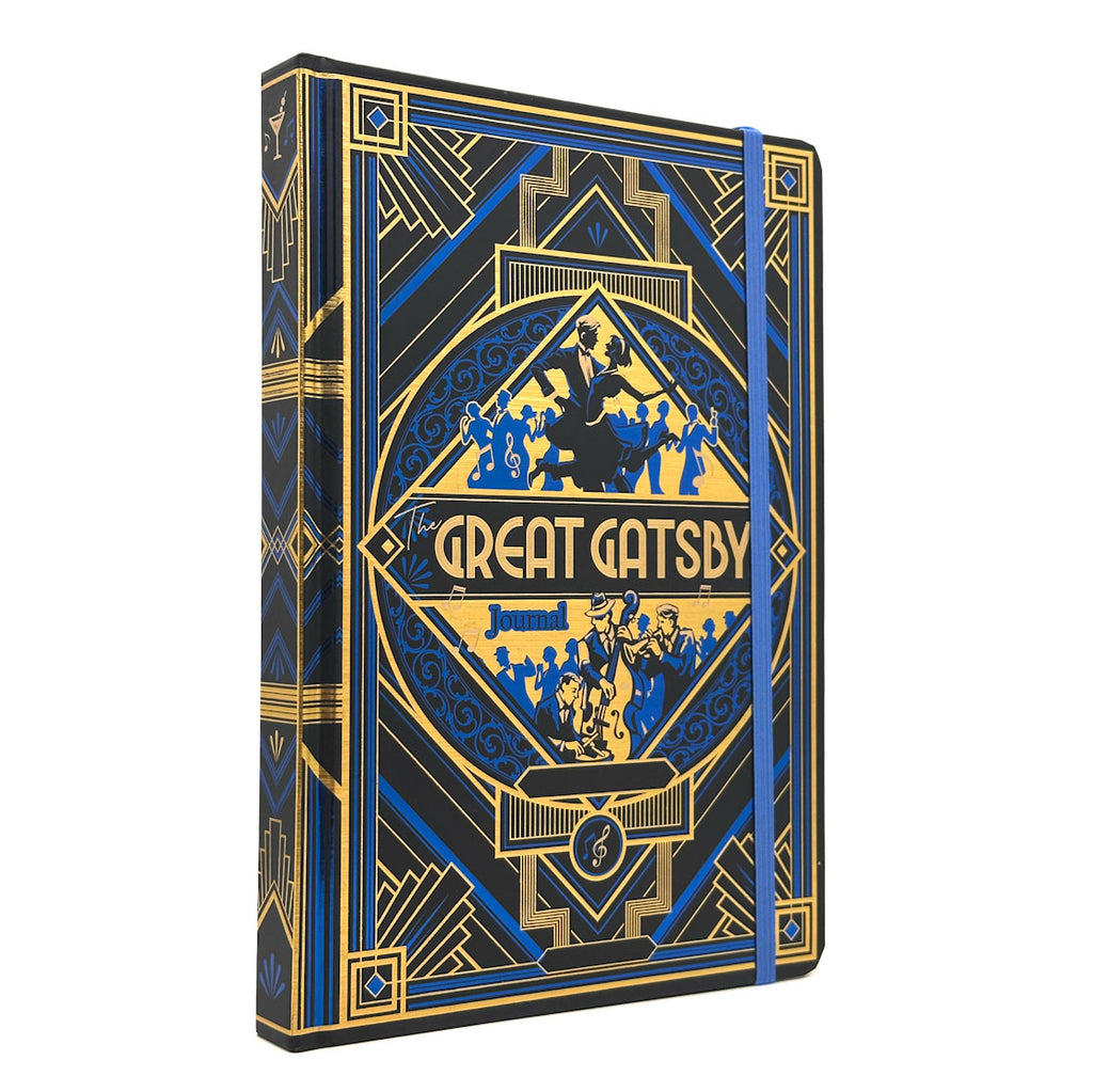 The Great Gatsby hardcover journal featuring an Art Deco design in black, blue, and gold. The cover displays a central diamond-shaped emblem with silhouettes of figures and the title 'The Great Gatsby' in gold lettering.