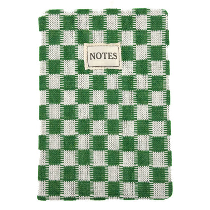 A woven notebook with a green and white checkered pattern, featuring a small beige label on the front that reads 'NOTES'.