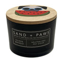 Guava Mango Black candle with a wooden lid featuring a dog and watermelon design, labeled 'Sand + Paws'.
