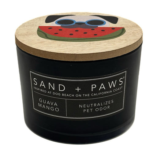 Guava Mango Black candle with a wooden lid featuring a dog and watermelon design, labeled 'Sand + Paws'.