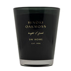 A black glass candle jar with gold lettering that reads 'HINOKI OAKMOSS', 'bright & fresh', and 'DW HOME EST. 1996' on a plain white background.