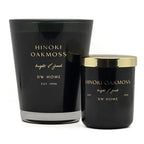 Two black Hinoki Oakmoss scented candles by DW Home, one large glass jar and one smaller jar with a gold lid, on a white background.