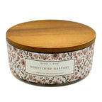 Honeycrisp candle with floral label and wooden lid on a white background