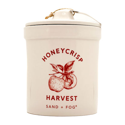 Ceramic candle container with 'Honeycrisp Harvest' design and 'Sand + Fog' branding on a white background