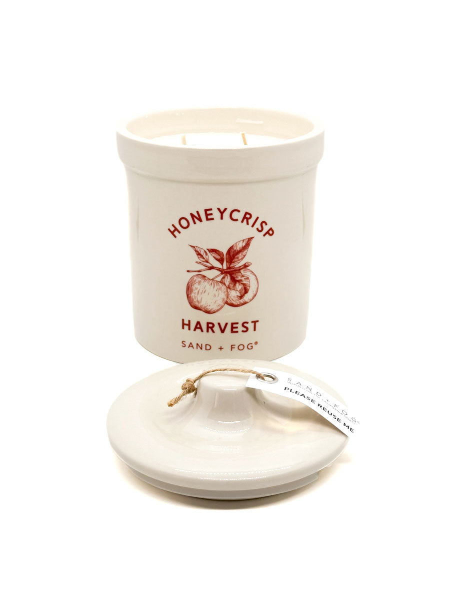 Ceramic candle container with 'Honeycrisp Harvest' text and apple illustration on a white background