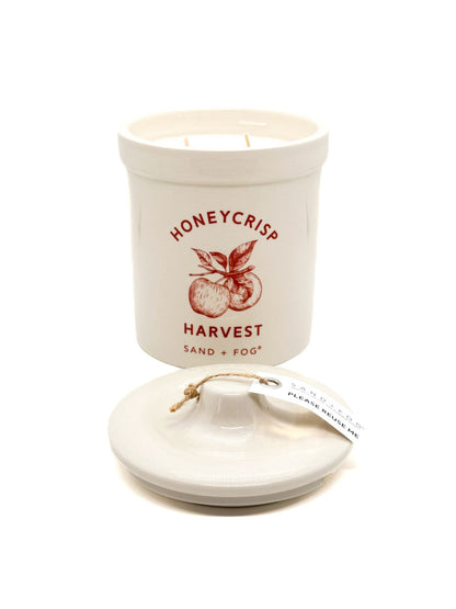 Ceramic candle container with 'Honeycrisp Harvest' text and apple illustration on a white background