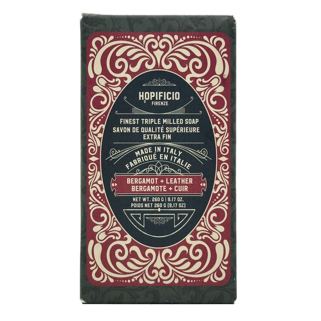 Bergamot + Leather bar of soap with decorative packaging on a white background