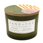 Jasmine Amaranth candle with a decorative lid featuring abstract patterns and 'Sand + Fog' branding.