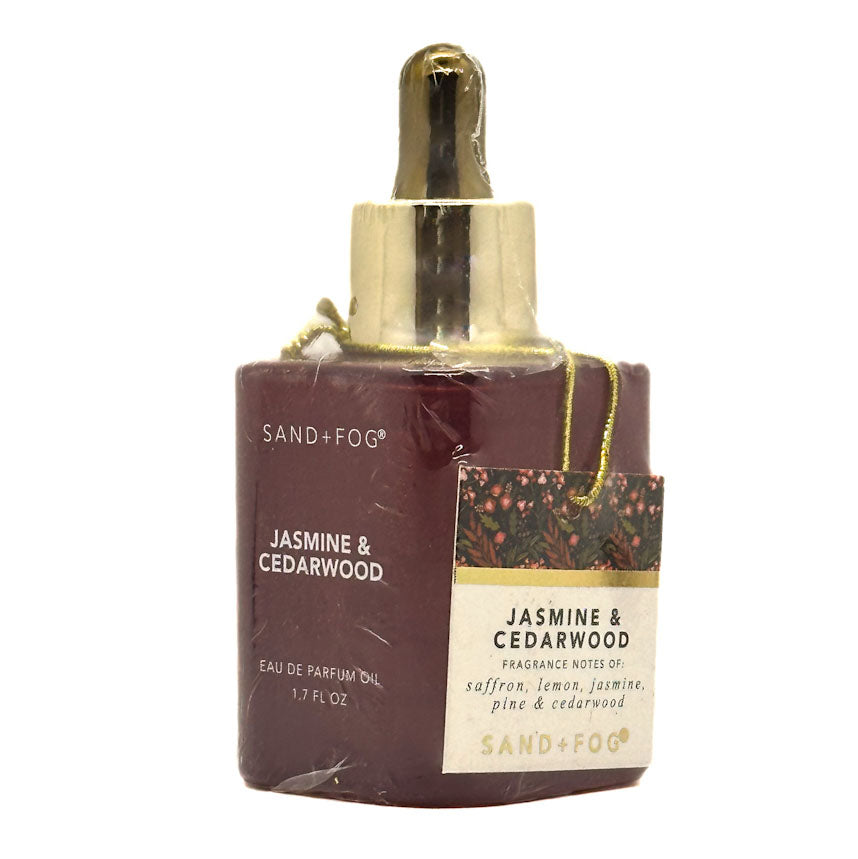 Eau de Parfum Oil with gold dropper labeled 'Jasmine & Cedarwood' by Sand + Fog on a white background.