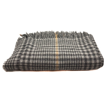 A folded plaid scarf or shawl in black and white with a thin beige stripe down the center and fringed edges, shown on a plain white background.