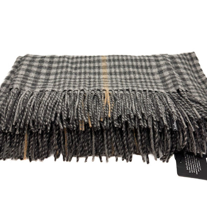 A folded plaid scarf with fringed edges in grey, black, and beige tones, shown on a white background with a small black product tag attached.