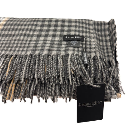 A folded plaid fringed scarf in gray, black, and white with subtle tan accents, featuring a Joshua Ellis label and a black product tag on a white background.