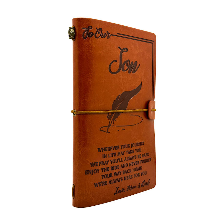 Brown leather notebook with engraved text on a white background