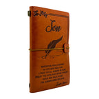 Brown leather notebook with engraved text on a white background