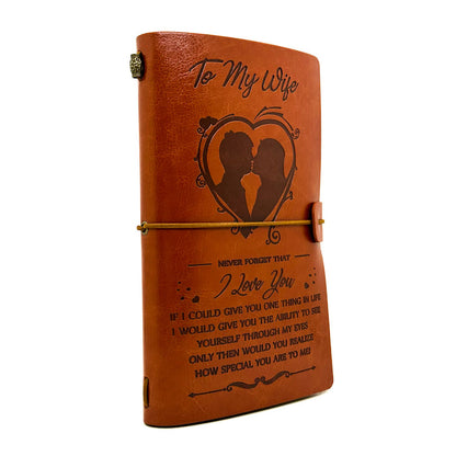 Brown leather journal with engraved message and design on a white background