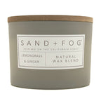 Gray Lemongrass & Ginger candle with a wooden lid labeled 'Sand + Fog' on a white background