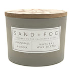 Gray Lemongrass & Ginger candle with a wooden lid labeled 'Sand + Fog' on a white background