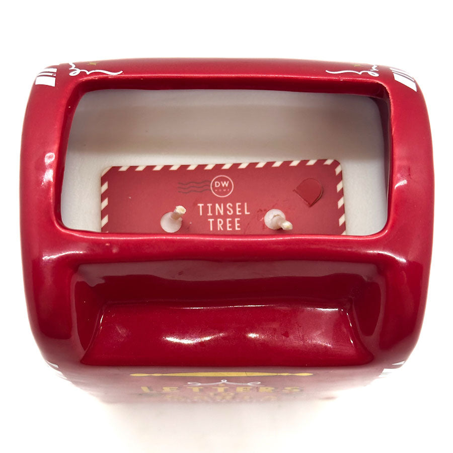 Red vintage-style candle with 'DW Tinsel Tree' branding on a white background