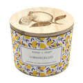 SAND + FOG Limoncello Candle with wooden lid featuring lemon design and 'Sand + Fog' branding.