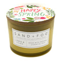 Linen & Lilies Candle with 'Happy Spring' lid and Sand + Fog label on a white background