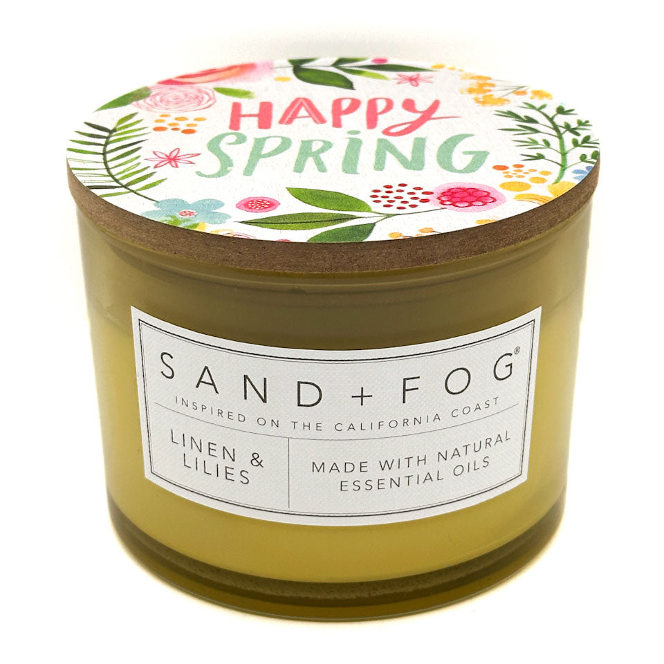 Linen & Lilies Candle with 'Happy Spring' lid and Sand + Fog label on a white background