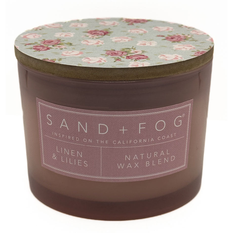 Linen & Lillies candle with floral lid and 'Sand + Fog' label on a white background