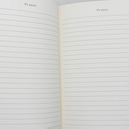 Open notebook with lined pages and 'it's yours.' text on a white background