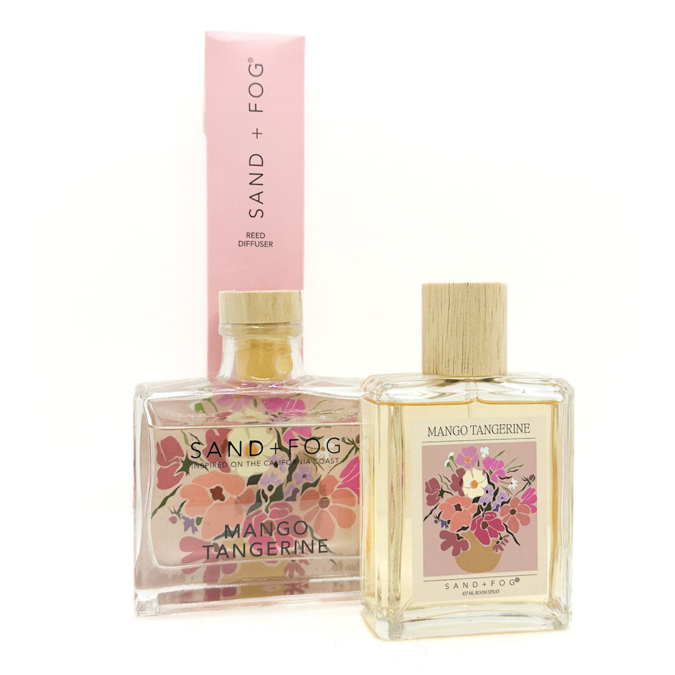 Sand + Fog Mango Tangerine Room Spray & Reed Diffuser bottles with floral designs on a white background